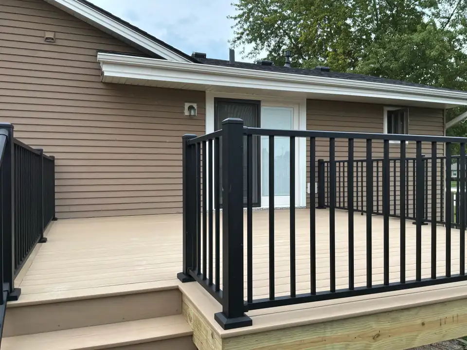 Finished composite deck with black aluminum railings off a patio door