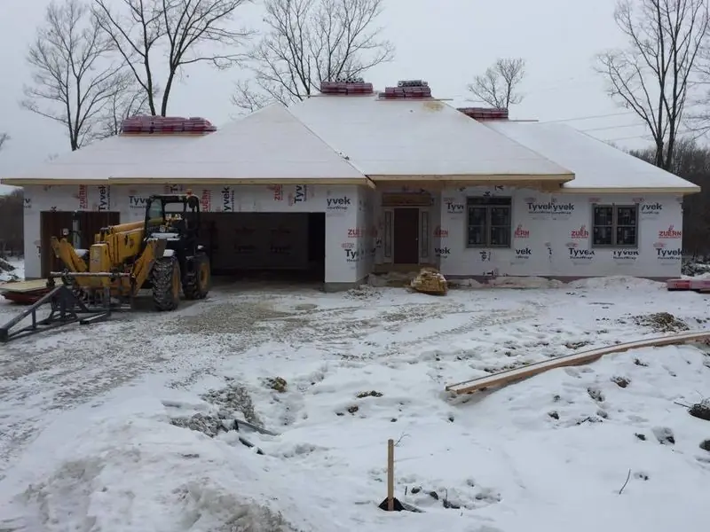 Ranch home and garage framed in winter snow
